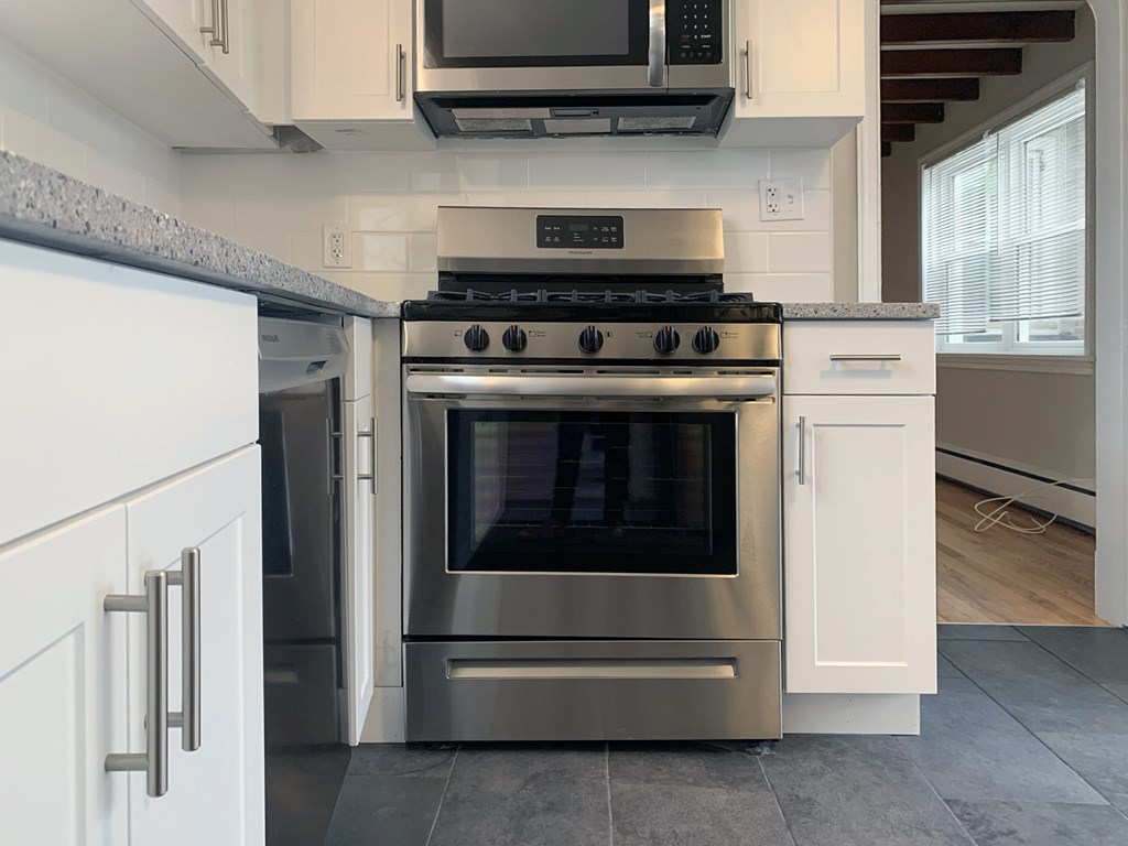 a kitchen with stainless steel appliances and white cabinets