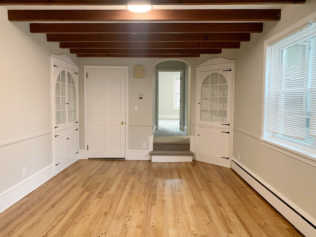 a living room with a hard wood floor and white doors