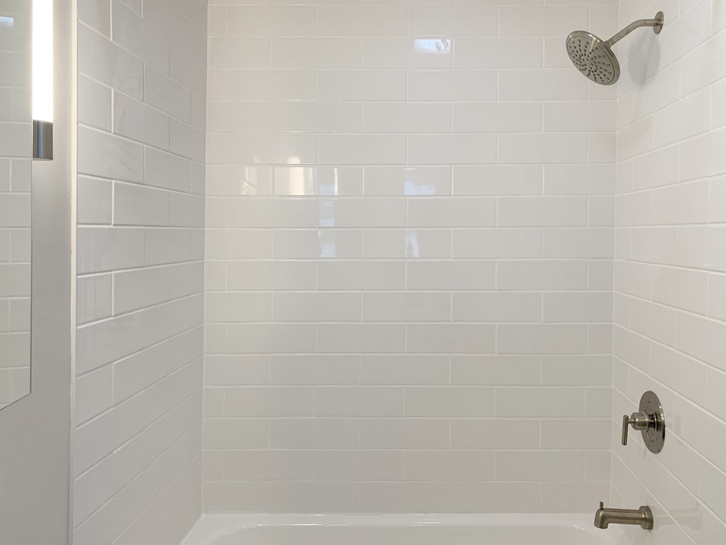 a white bathroom with a shower and a tub