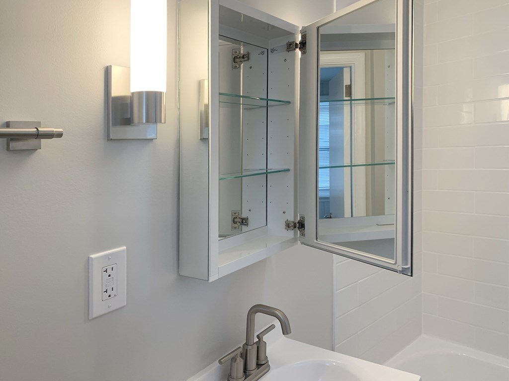 a white bathroom with a sink and a mirror