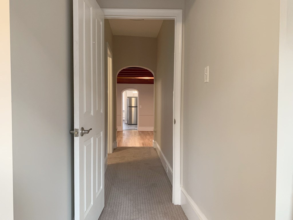 a hallway with a door open to a room with an open door to a house