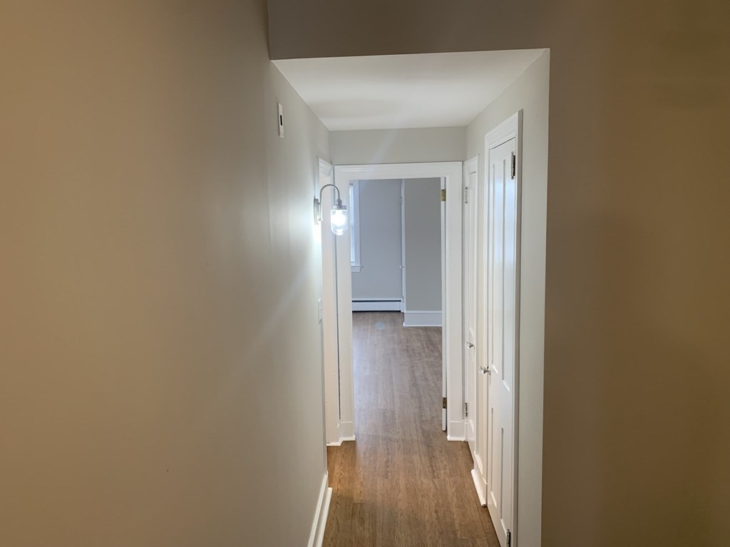 an empty room with a hallway and a door to a bedroom