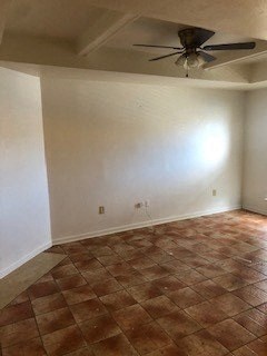 an empty room with a ceiling fan and a tiled floor