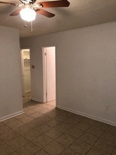 an empty living room with a ceiling fan