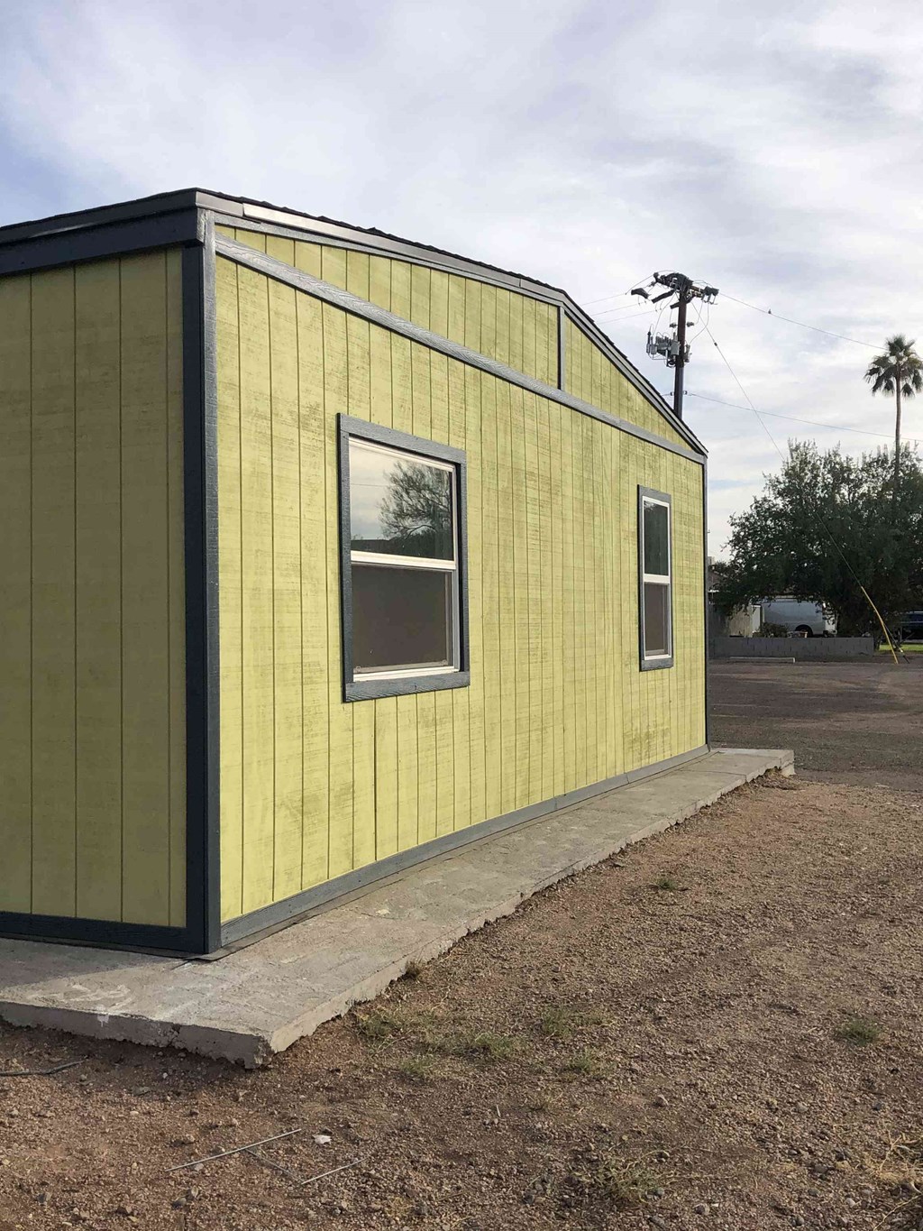 a small yellow building with a window on the side of it