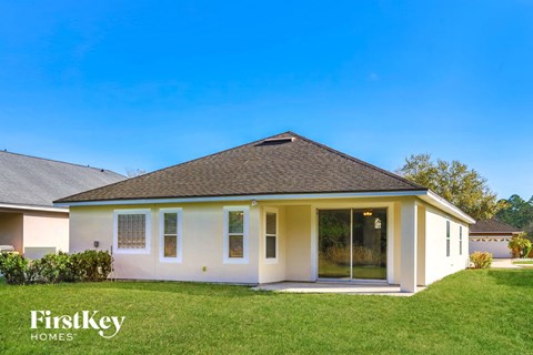 A house with a white exterior and a brown roof is shown with the words "FirstKey Homes" on the bottom left.