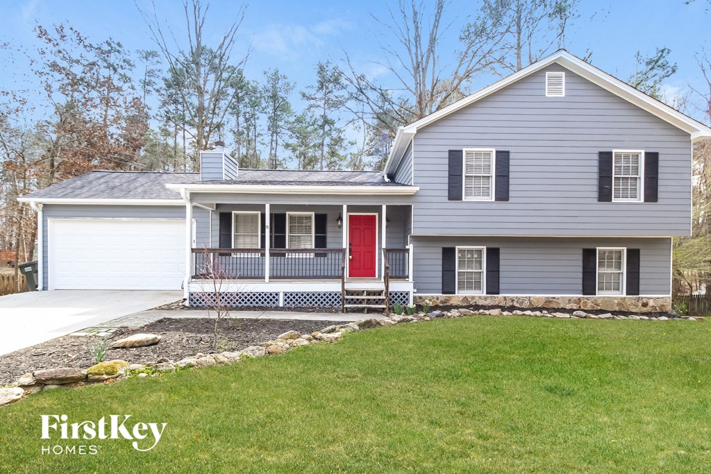 a blue house with a red door and a lawn