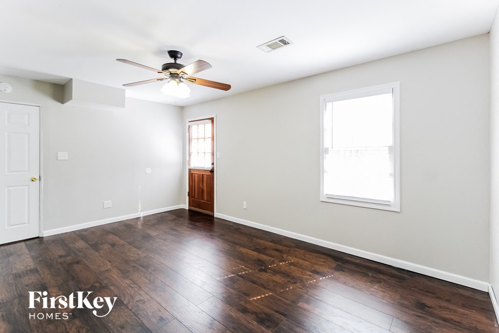 a living room with wood floors and a ceiling fan