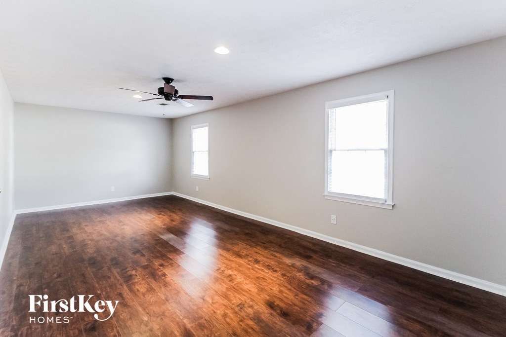 the living room with hardwood floors and a ceiling fan