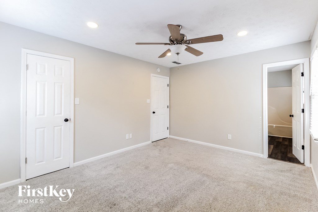a empty room with a ceiling fan and a closet