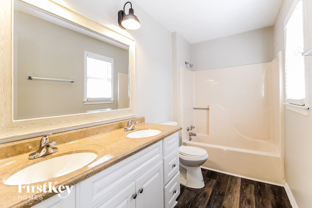 a bathroom with a toilet and a sink and a mirror