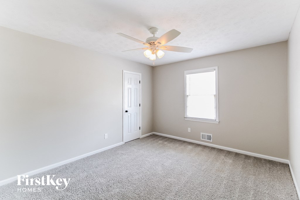 a bedroom with white carpet and a ceiling fan