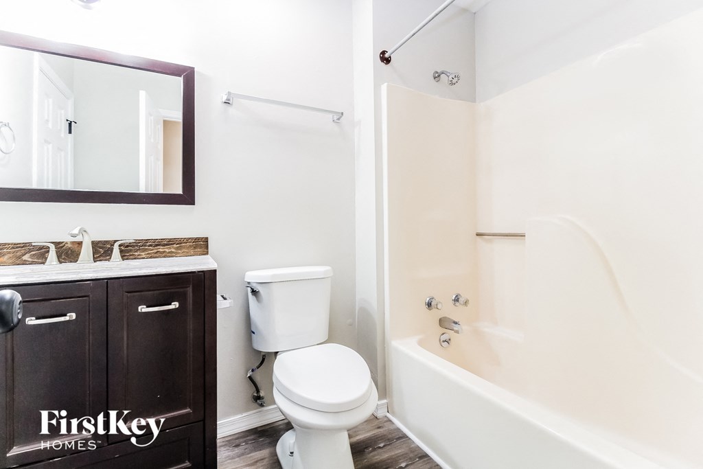a bathroom with a toilet and a tub and a sink