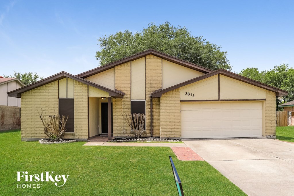 A house with a garage and a driveway is for sale.