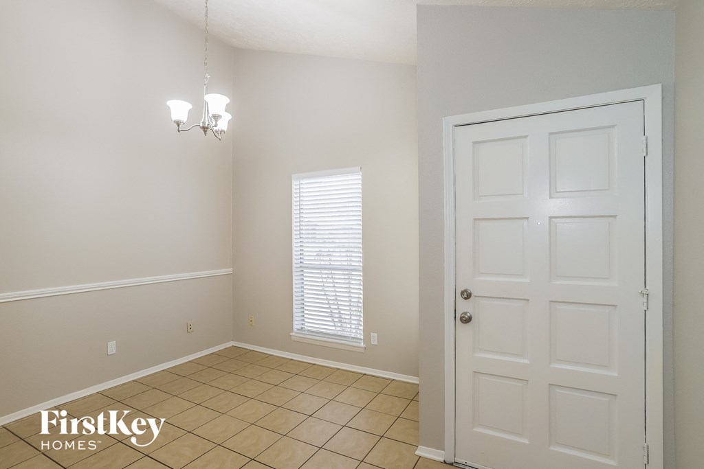 A room with a white door and a window with blinds.