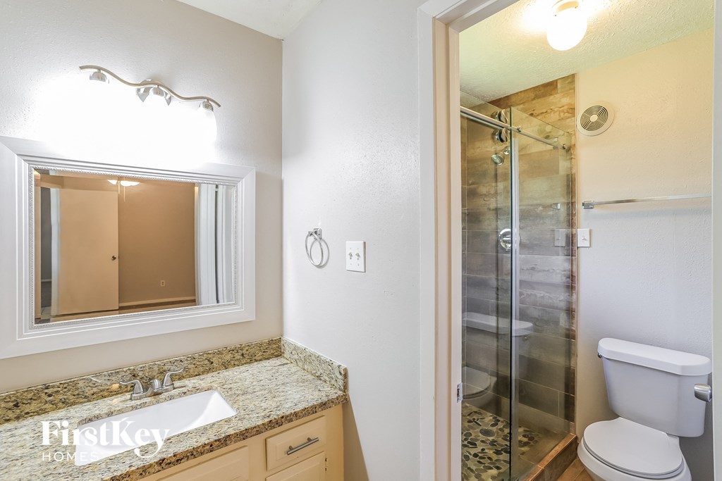 A bathroom with a sink, mirror, and toilet.