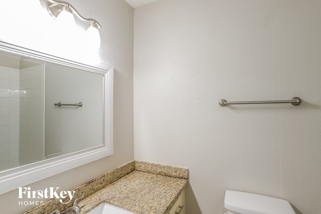 A white toilet sits next to a glass shower door in a small bathroom.