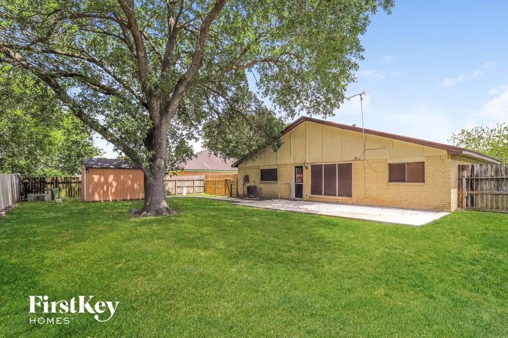 A tree in a yard in front of a house.