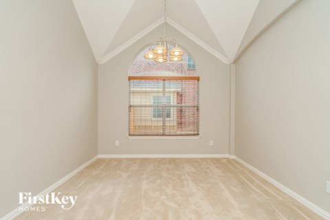 the second bedroom has a vaulted ceiling and a large window