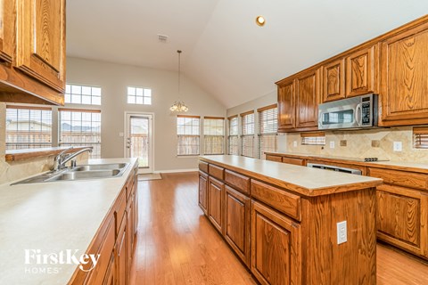 a large kitchen with wooden cabinets and counter tops and a sink