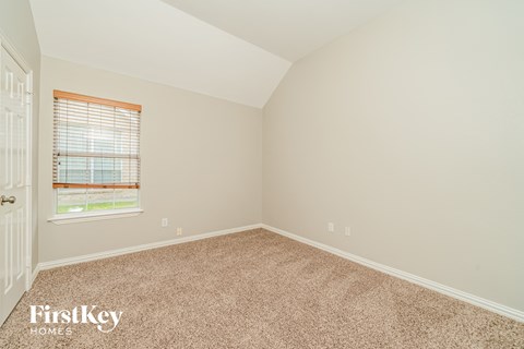 the bedroom of a home with carpet and a window