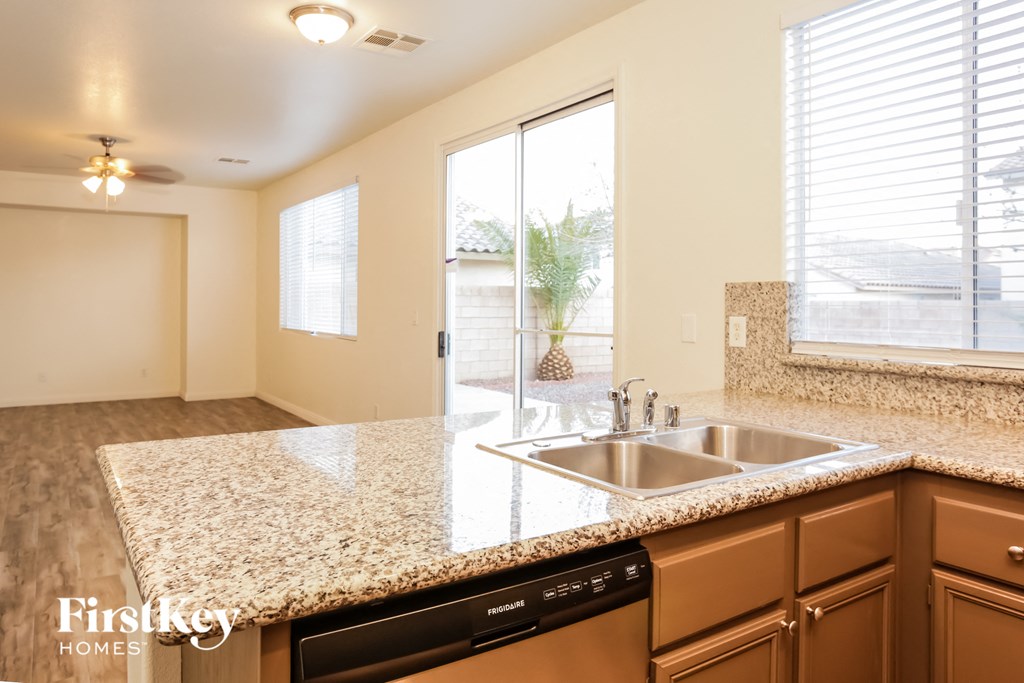 A kitchen with a granite countertop and a dishwasher.