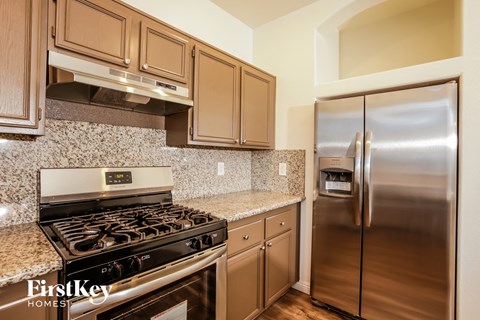 A kitchen with a stove top oven and a refrigerator.