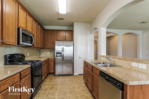 full kitchen with granite counter tops and stainless steel appliances