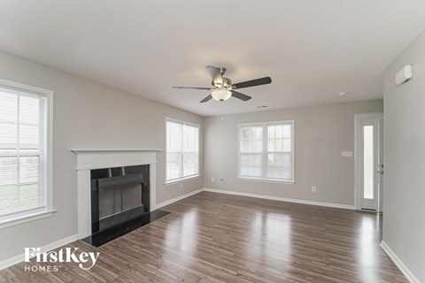 a living room with a fireplace and a ceiling fan