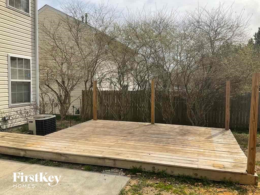 a backyard deck with a fence and a house