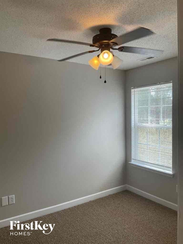 a bedroom with a ceiling fan and a window