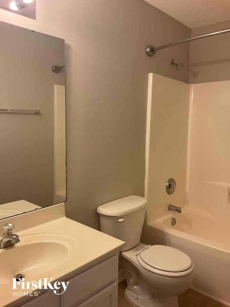 a bathroom with a toilet and a sink and a bath tub