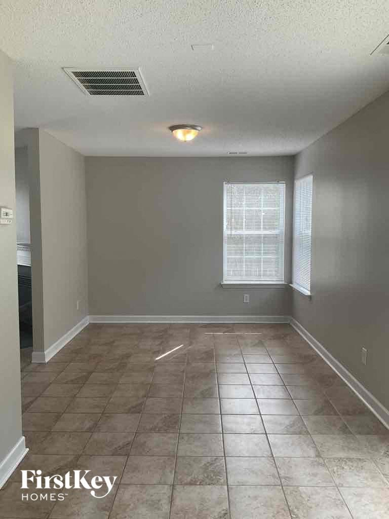 an empty living room with tile flooring and a window