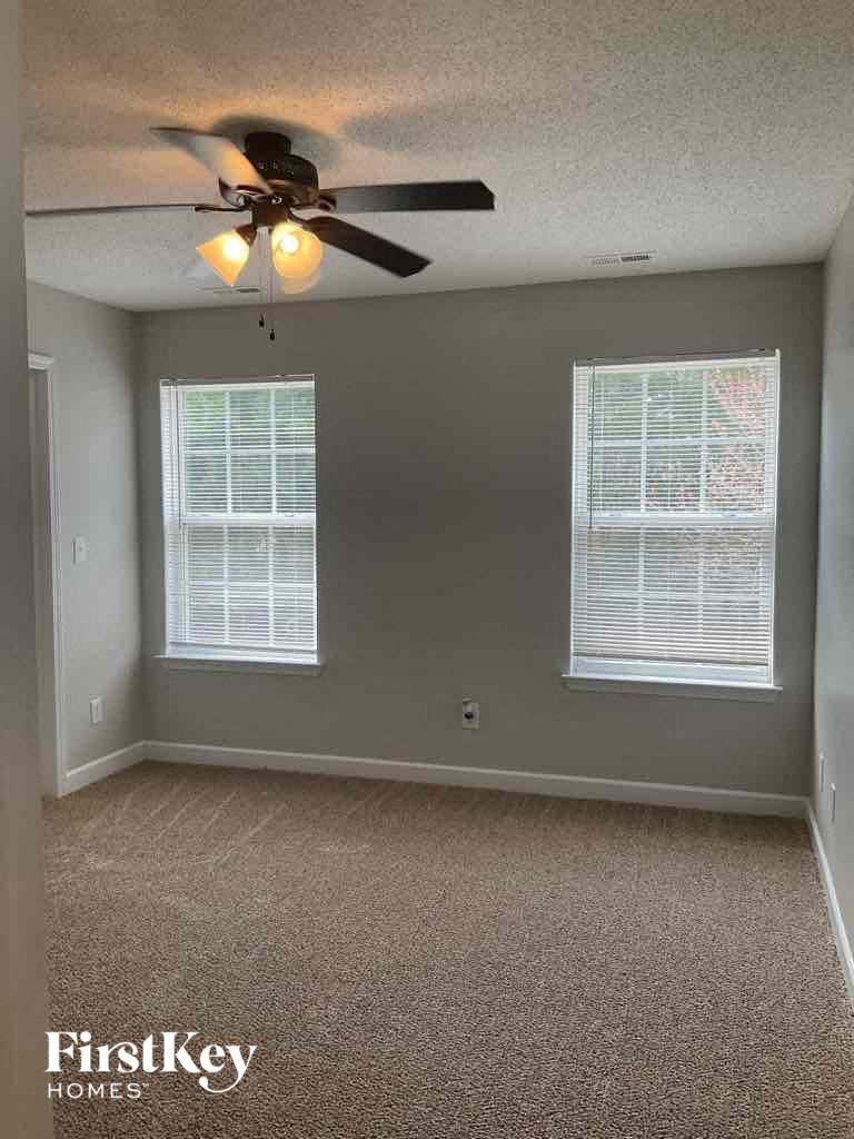 a empty room with a ceiling fan and two windows