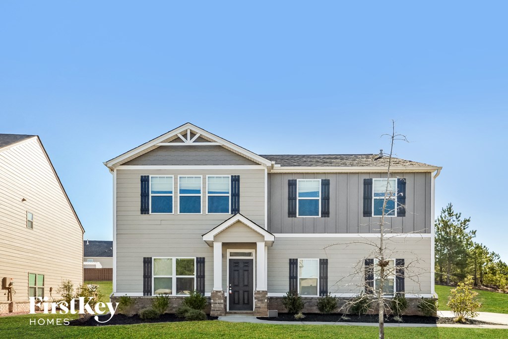 a house with a blue sky in the background and a green lawn