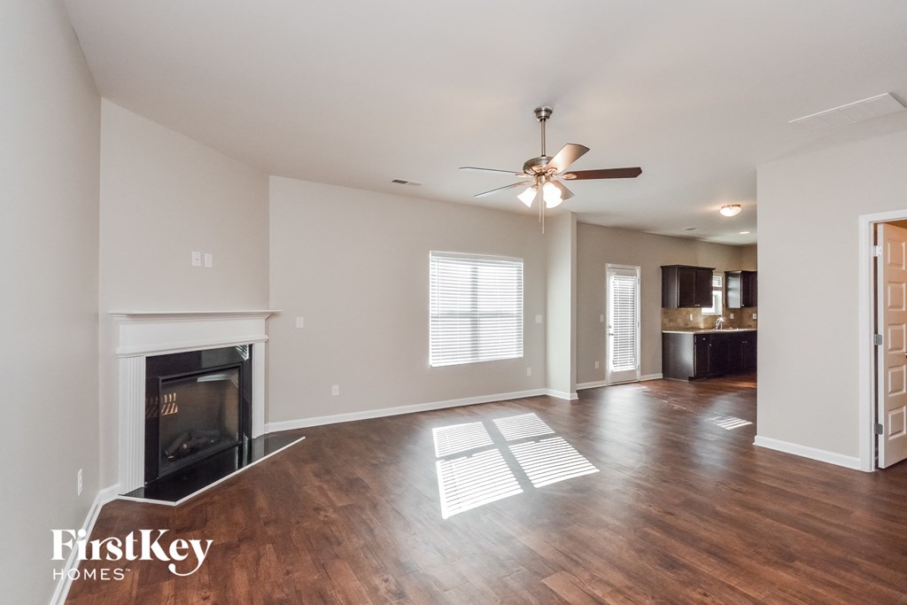 a living room with a fireplace and a ceiling fan