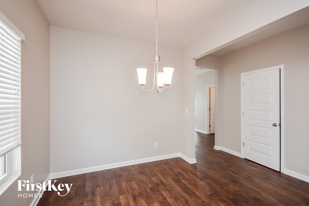 a living room with a hard wood floor and a white door