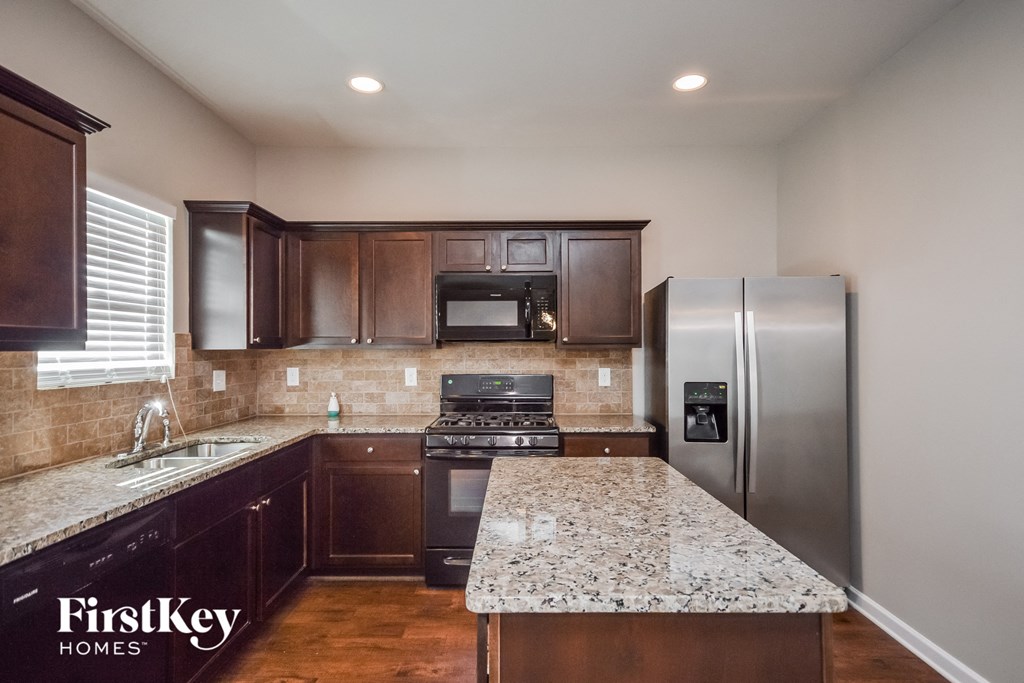 an updated kitchen with granite countertops and stainless steel appliances