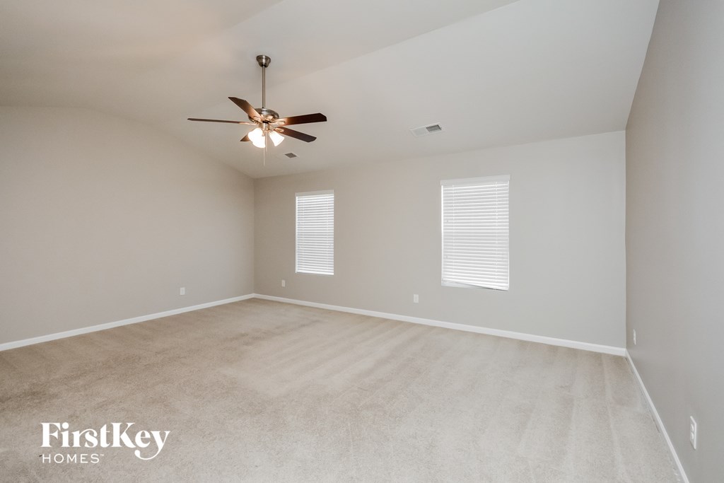 an empty living room with a ceiling fan