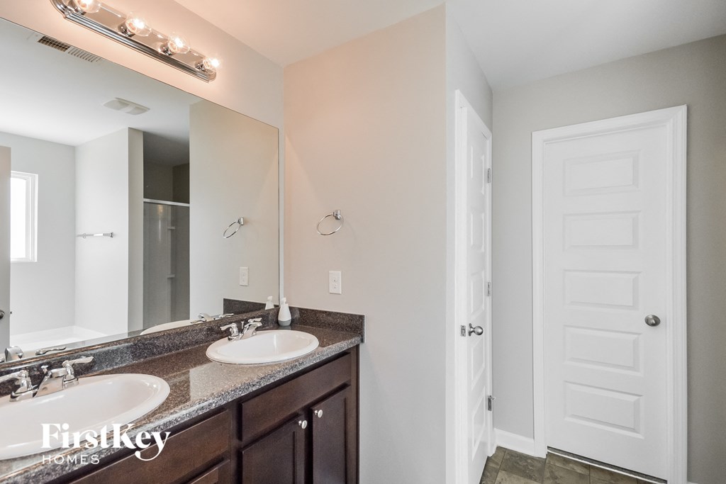 a bathroom with two sinks and a large mirror