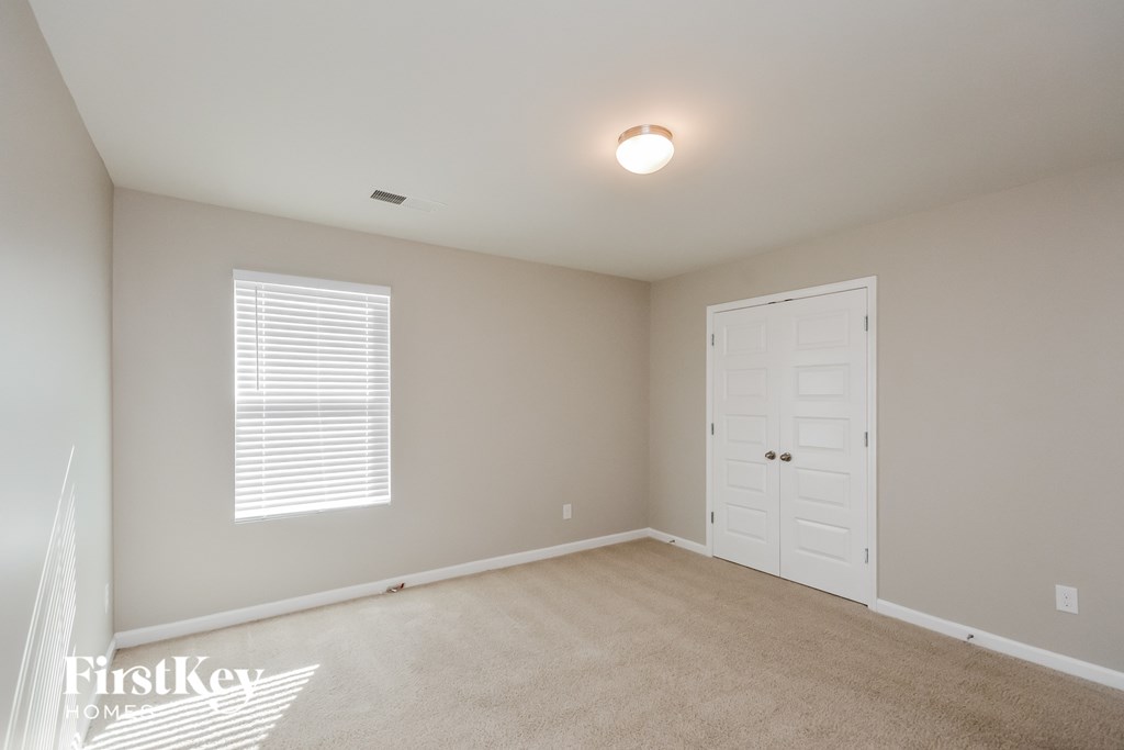a bedroom with a white door and a carpeted floor