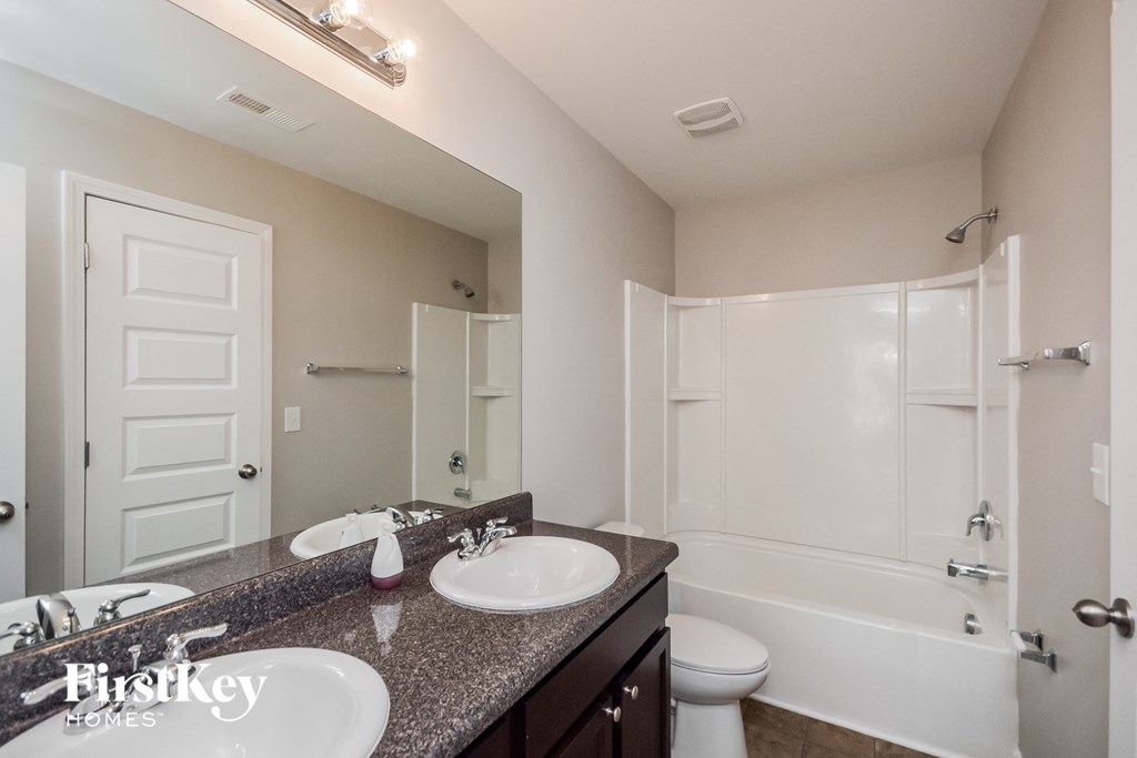 a bathroom with two sinks and a shower and a toilet