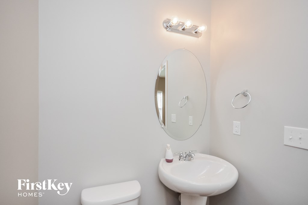 a bathroom with a sink and a mirror and a toilet