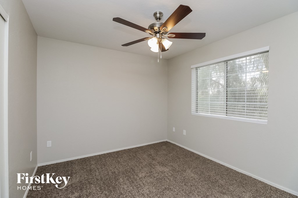 a bedroom with a ceiling fan and a window
