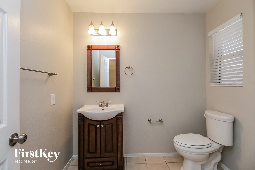 a bathroom with a toilet sink and a mirror