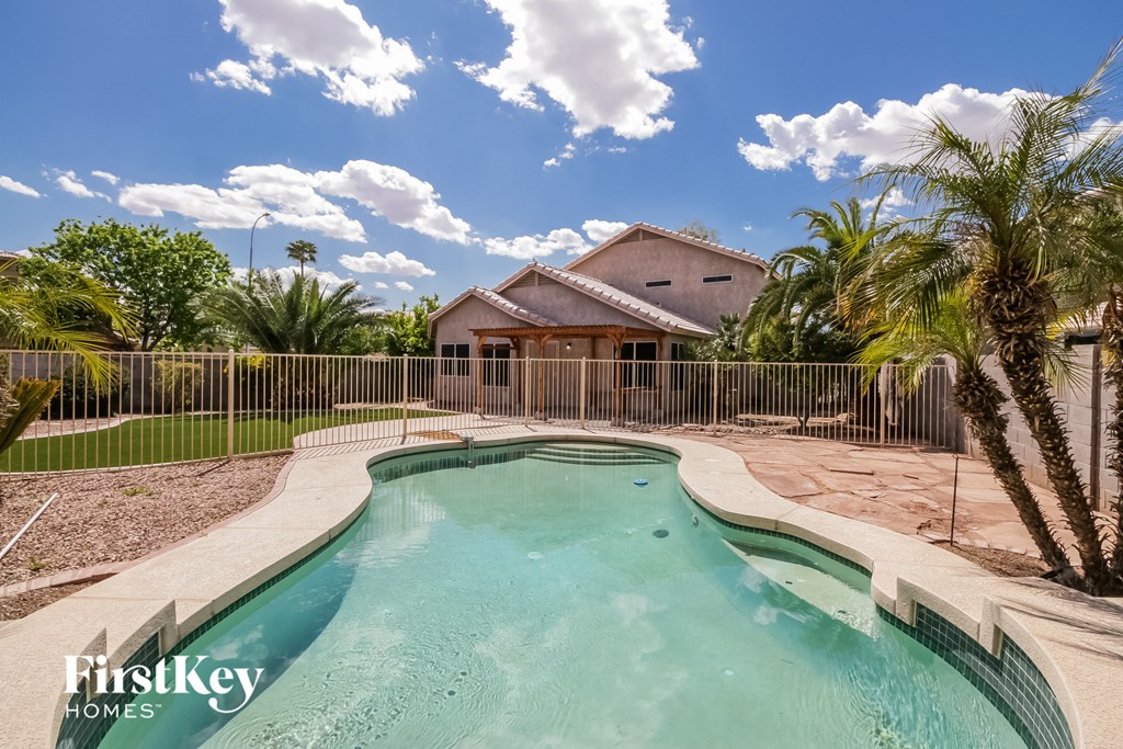 a swimming pool with a house in the background