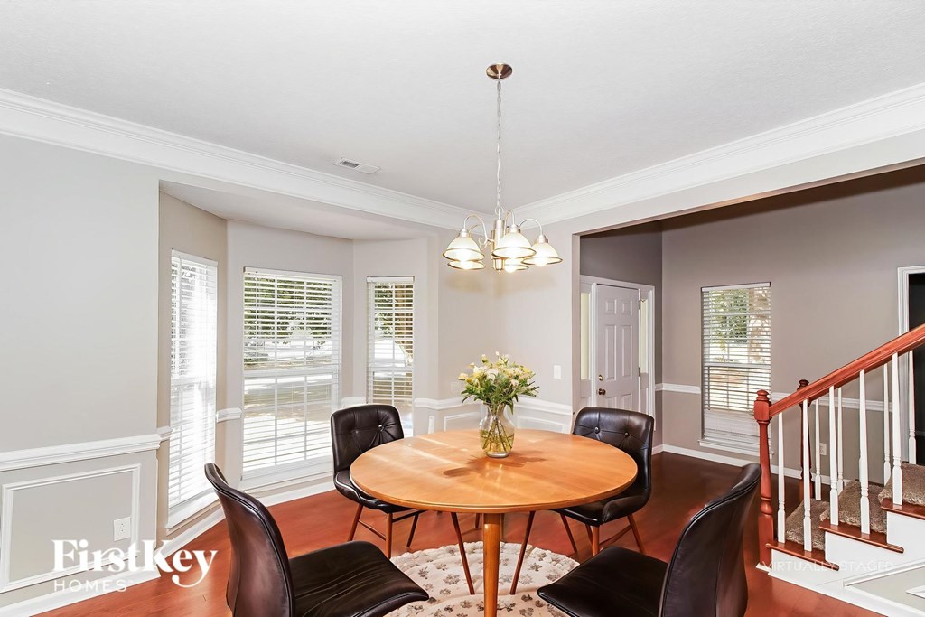A dining room with a round table and chairs.