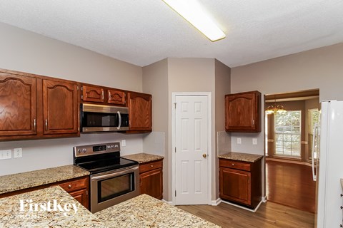 A kitchen with wooden cabinets and a granite countertop.