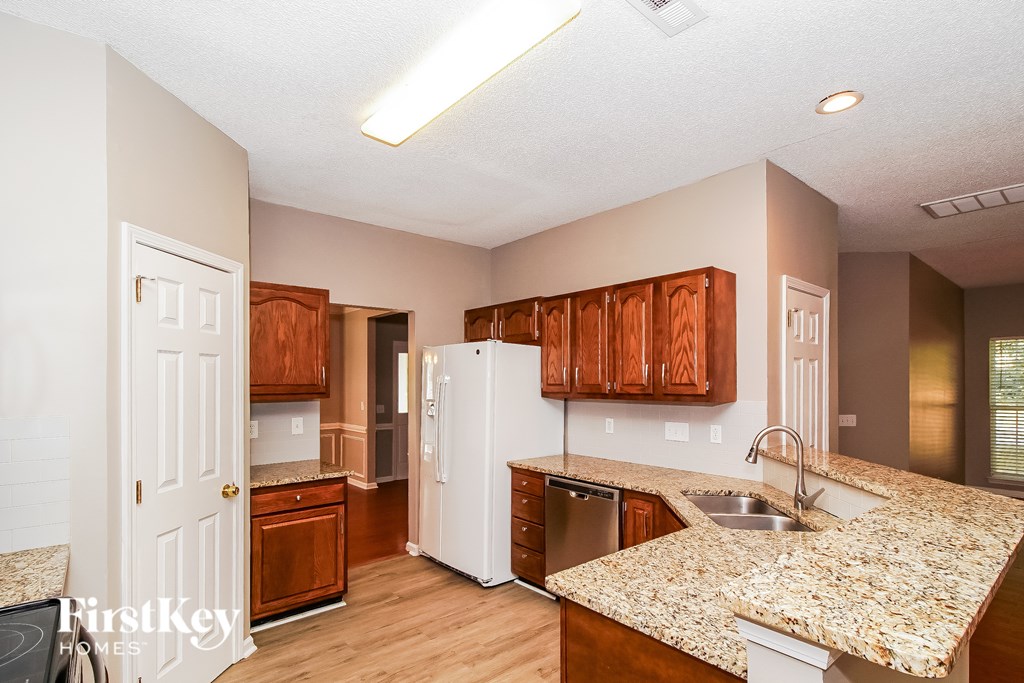 A kitchen with wooden cabinets and a granite countertop.