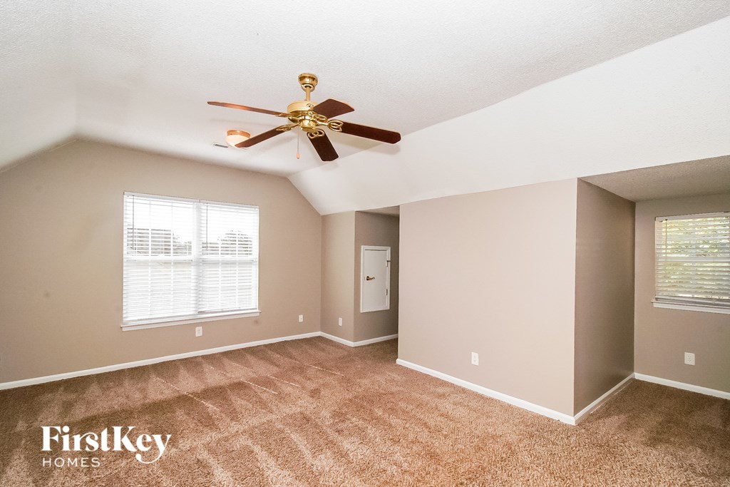 A room with a ceiling fan and a carpeted floor.